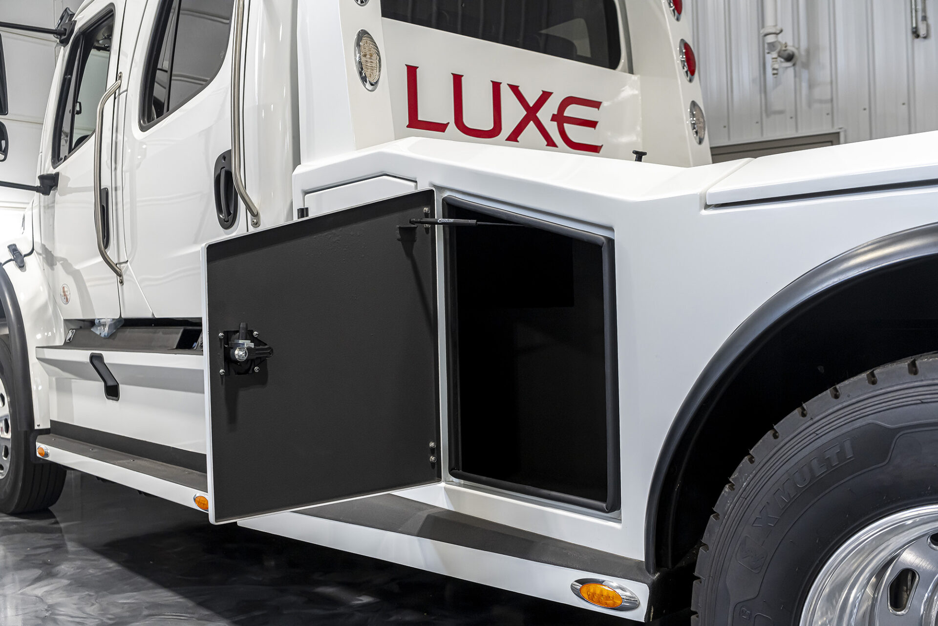 White Freightliner M2-106 with a hauler body build by Luxe Trucks in Elkhart, Indiana.
