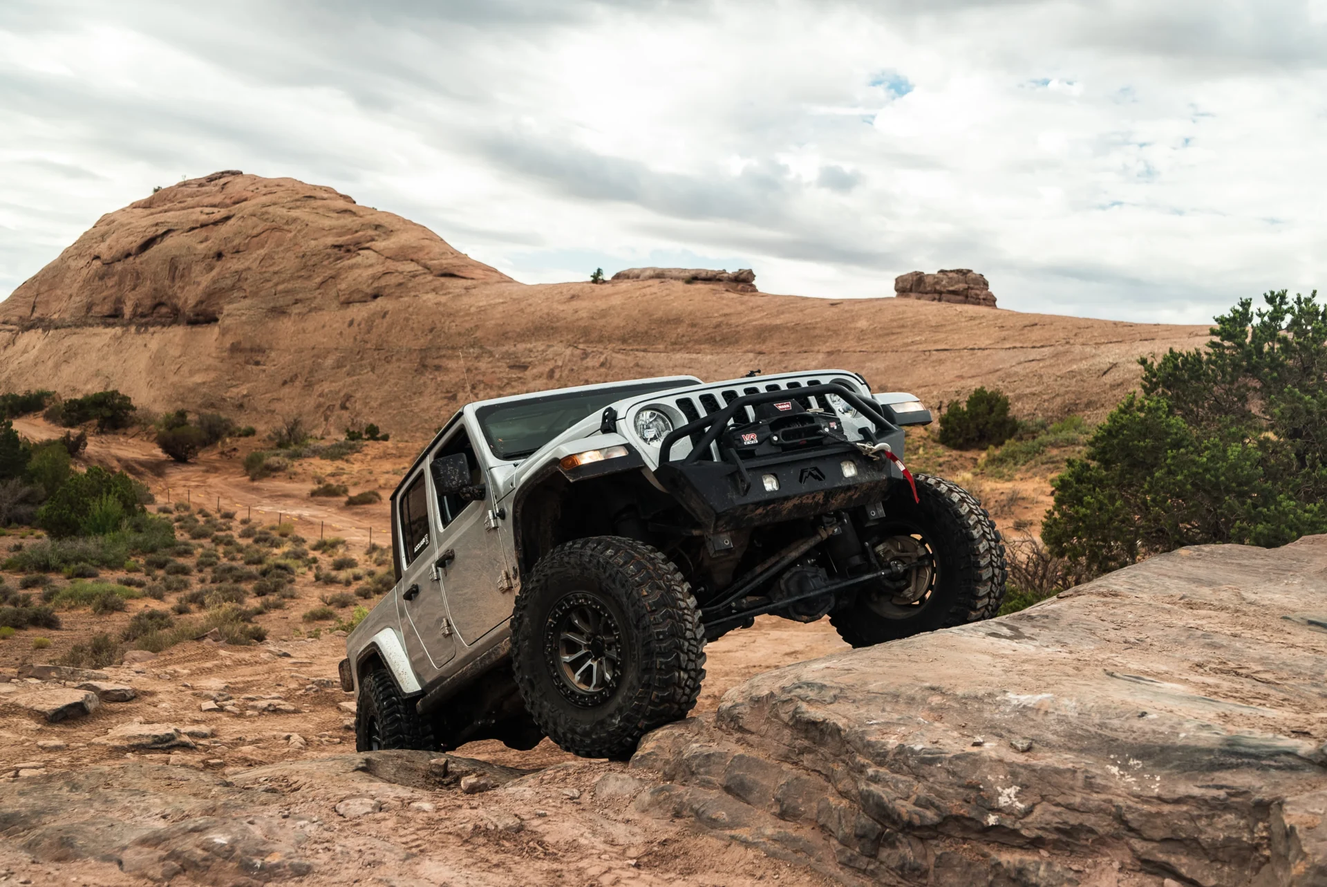 A Jeep Gladiator going off-road and rock climbing with an AccuAir air suspension upgrade.