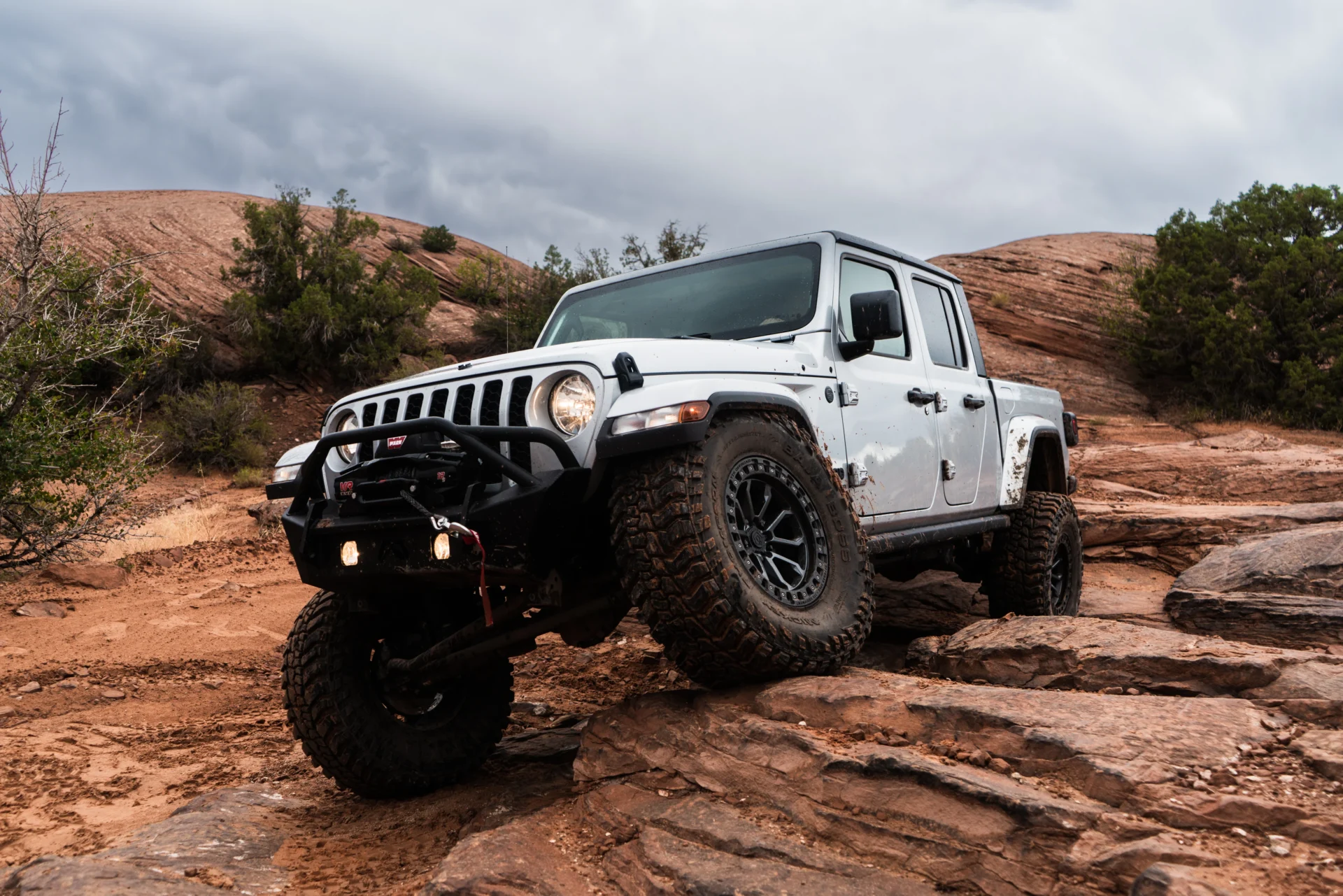 A Jeep Gladiator going off-road and rock climbing with an AccuAir air suspension upgrade.